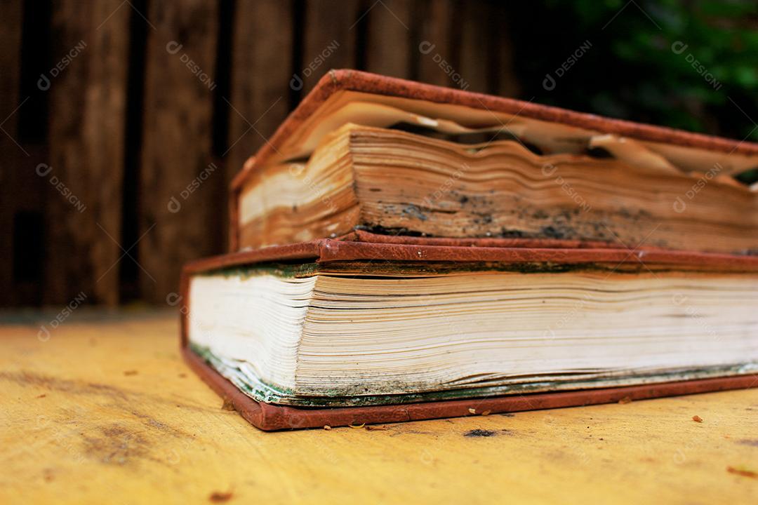 Livros empilhados sobre uma mesa de madeira