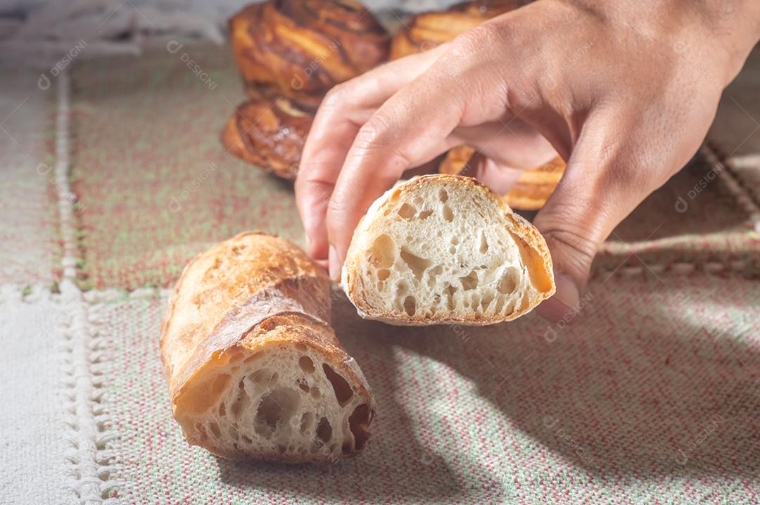 Pão artesanal em uma mesa de mãos dadas, luz suave.