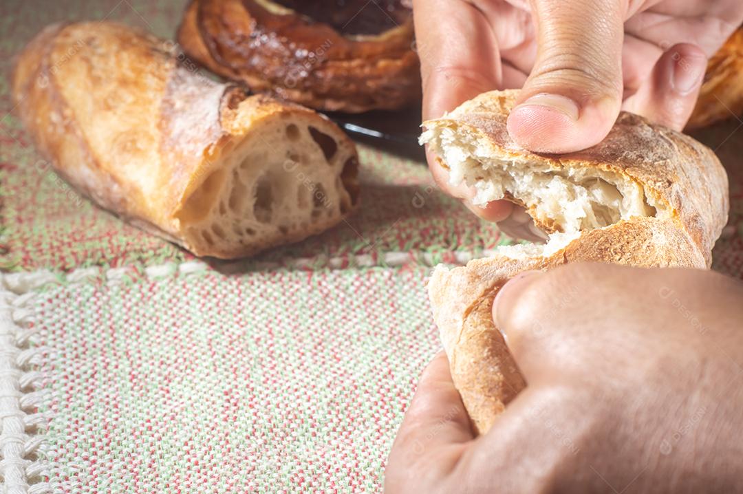 Pão artesanal em uma mesa de mãos dadas, luz suave.