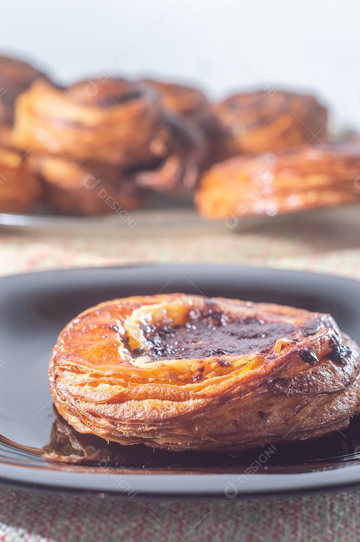 Massa folhada doce recheada com geleia de jabuticaba em prato preto com luz suave.
