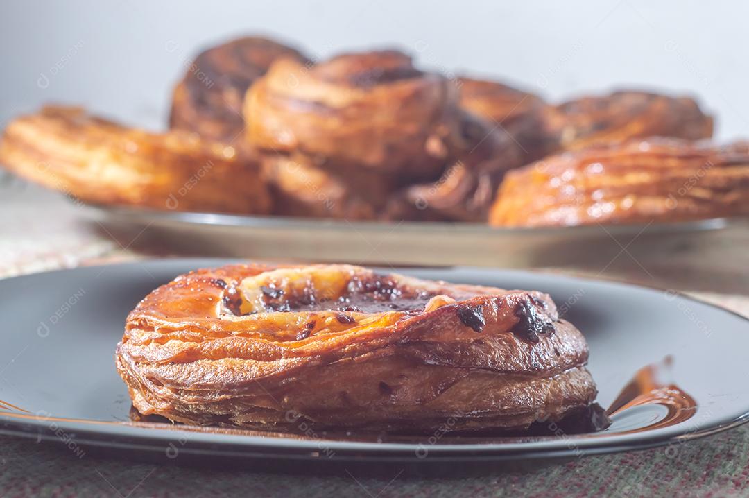 Massa folhada doce recheada com geleia de jabuticaba em prato preto com luz suave.