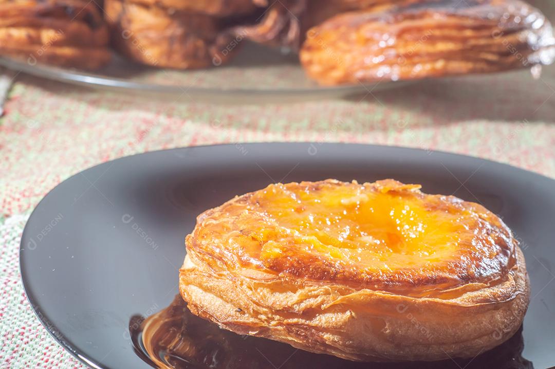 Sweet puff pastry stuffed with jabuticaba jelly on a black plate with soft light.