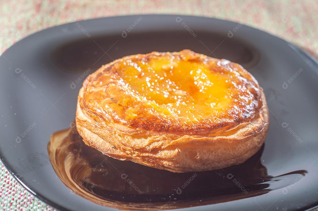 Massa folhada doce recheada com geleia de jabuticaba em prato preto com luz suave.
