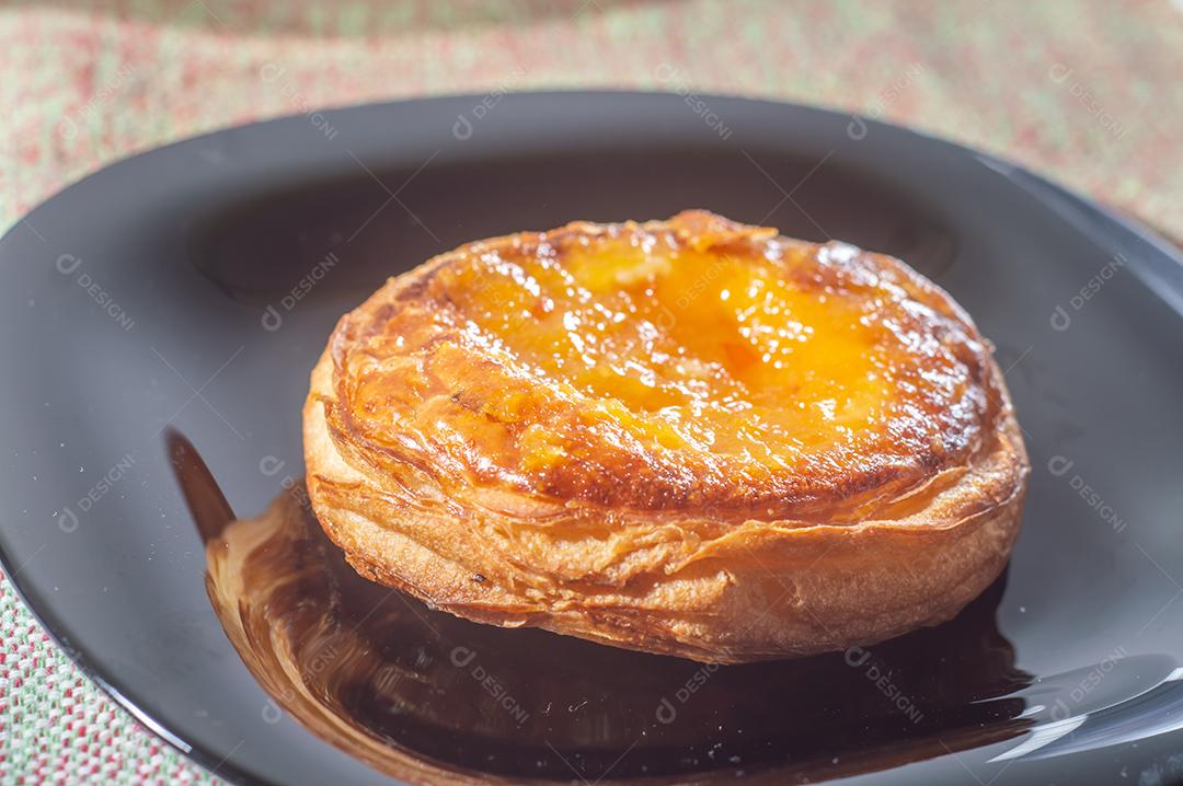 Massa folhada doce recheada com geleia de jabuticaba em prato preto com luz suave.
