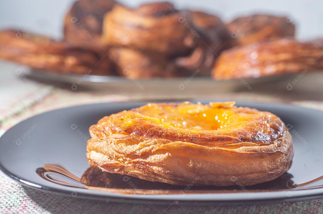 Massa folhada doce recheada com geleia de jabuticaba em prato preto com luz suave.