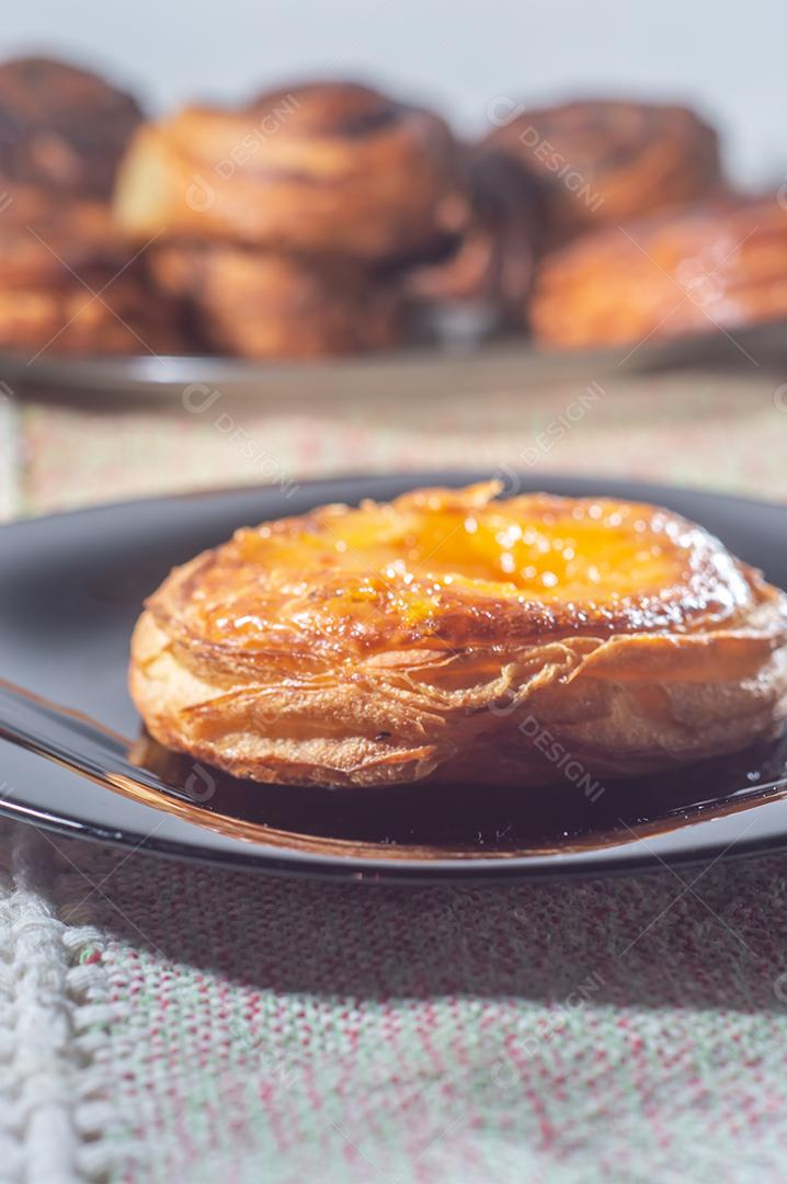 Massa folhada doce recheada com geleia de jabuticaba em prato preto com luz suave.
