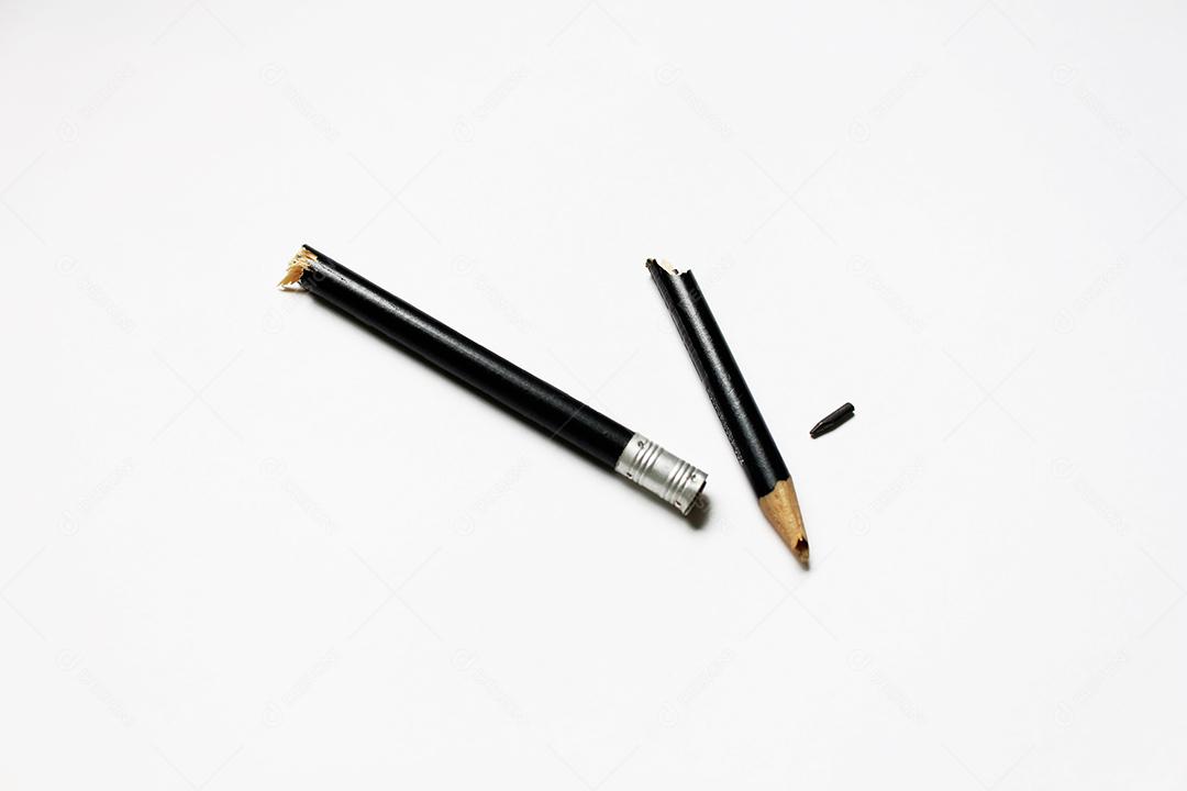 Lápis quebrado ao meio sobre fundo branco