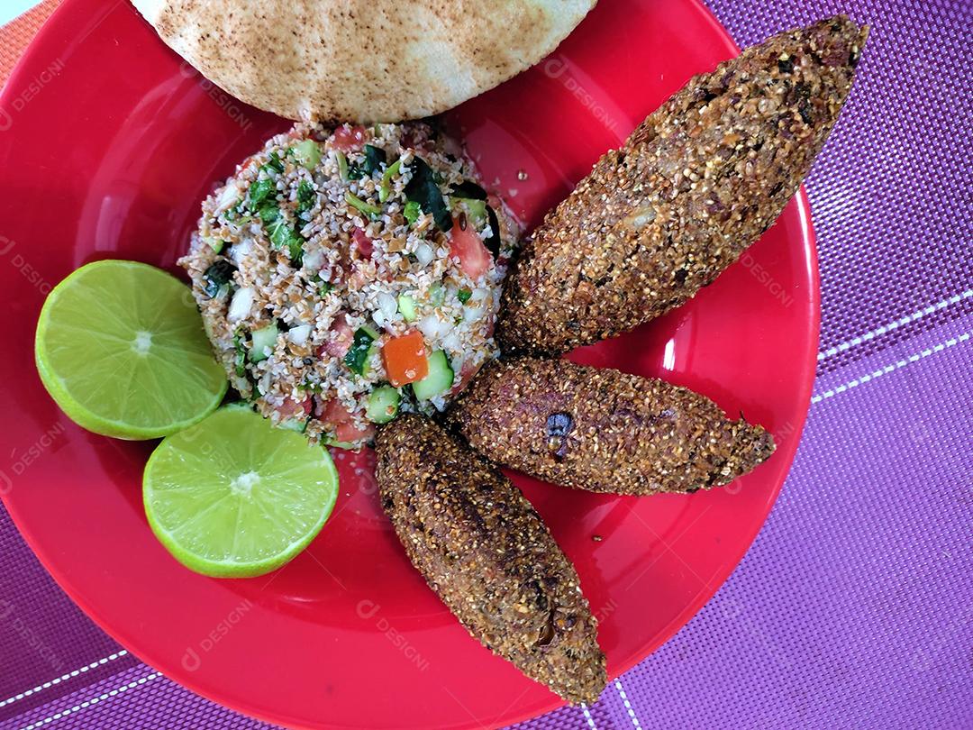 Comida quibe sobre prato vermelho alimentos frituras