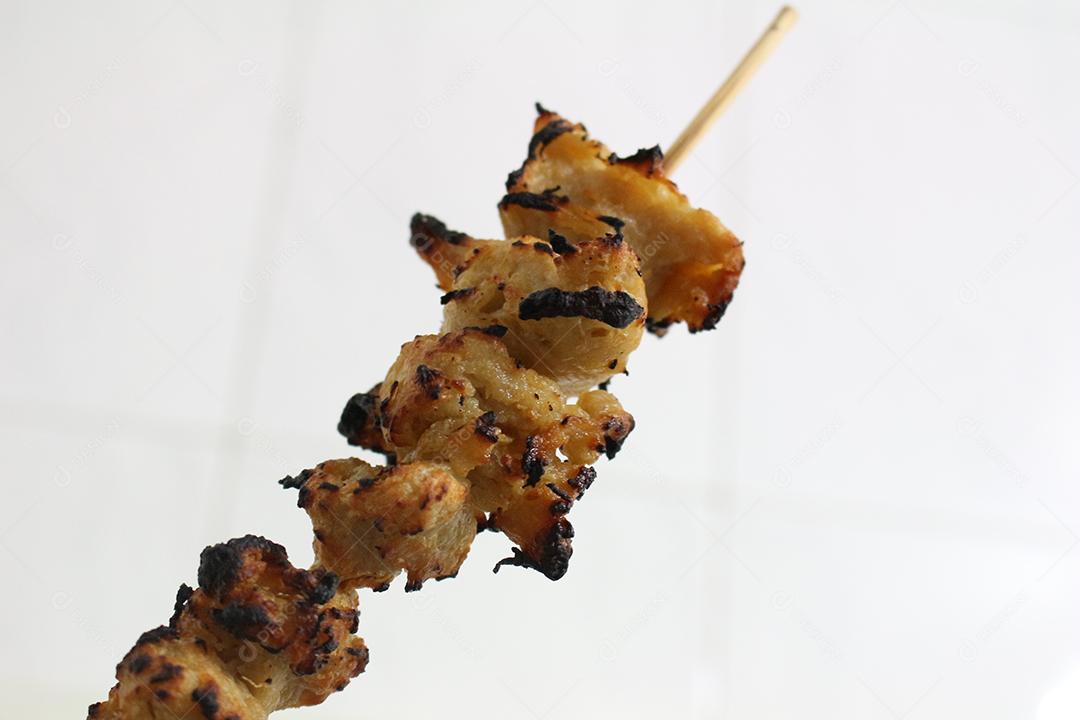 Comida sendo assada em espeto churrasco