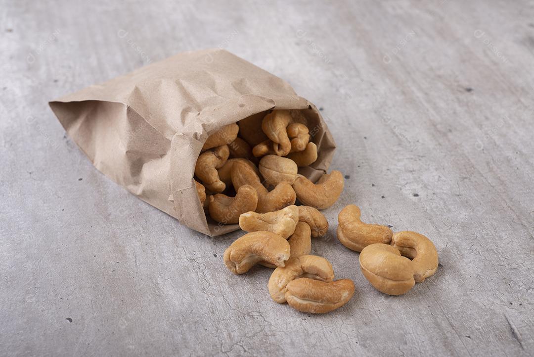 Um saco de castanha de caju brasileira sobre uma mesa de madeira.