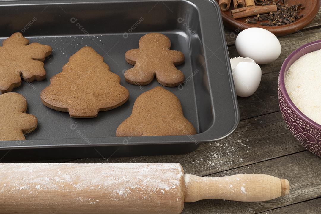 Pão de Natal tradicional com ingredientes sobre uma mesa de madeira.
