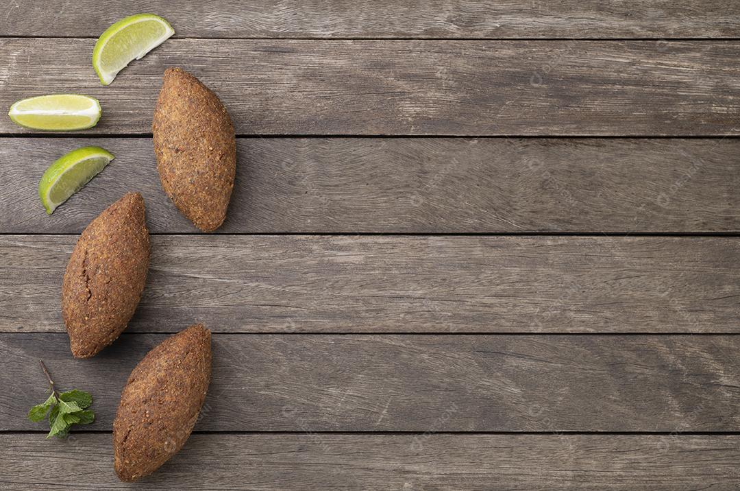 Quibe frito árabe tradicional sobre mesa de madeira. Lanche típico brasileiro.