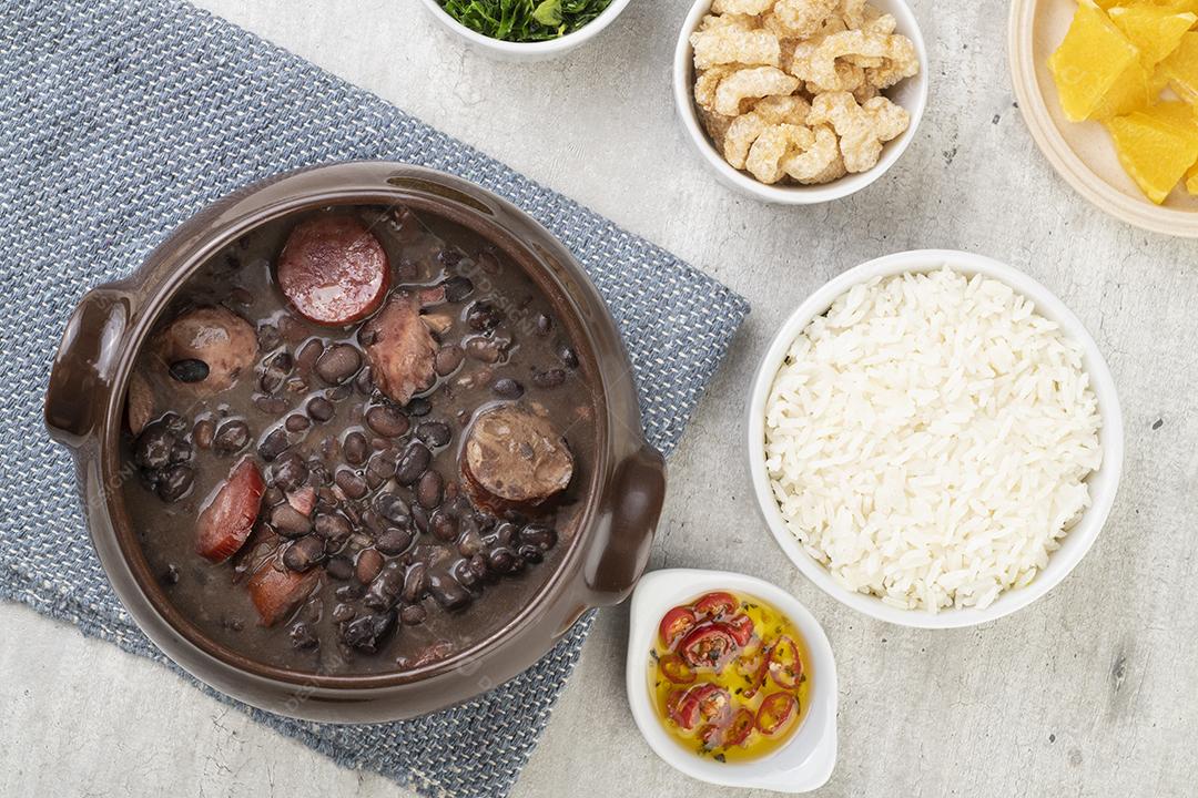 Tradicional feijoada brasileira com arroz, torresmo, couve e farinha de mandioca.