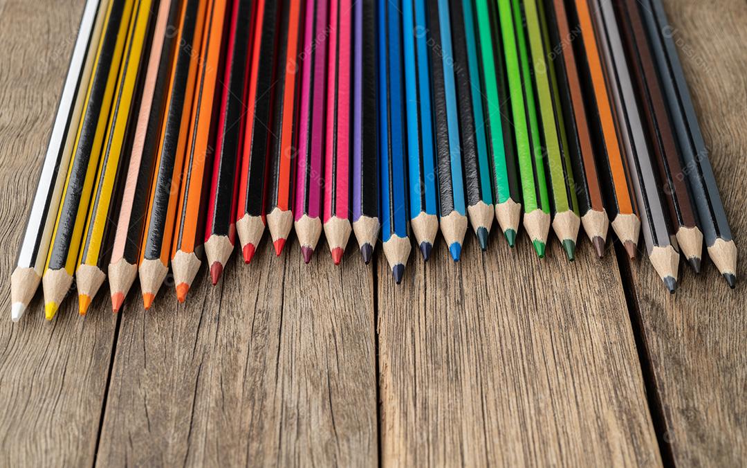 Lápis de cores sortidas sobre a mesa de madeira