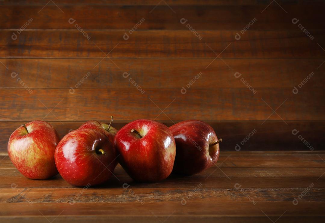 Várias maçãs vermelhas com fundo de madeira rústica