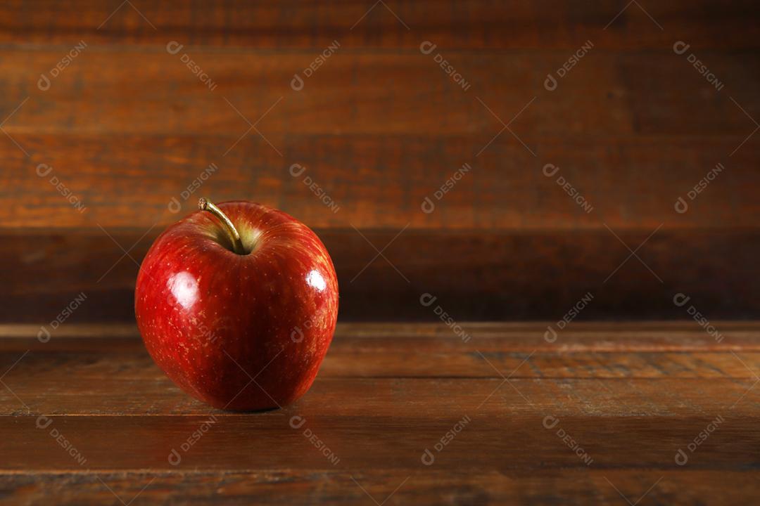 Maçã vermelha com fundo de madeira rústica
