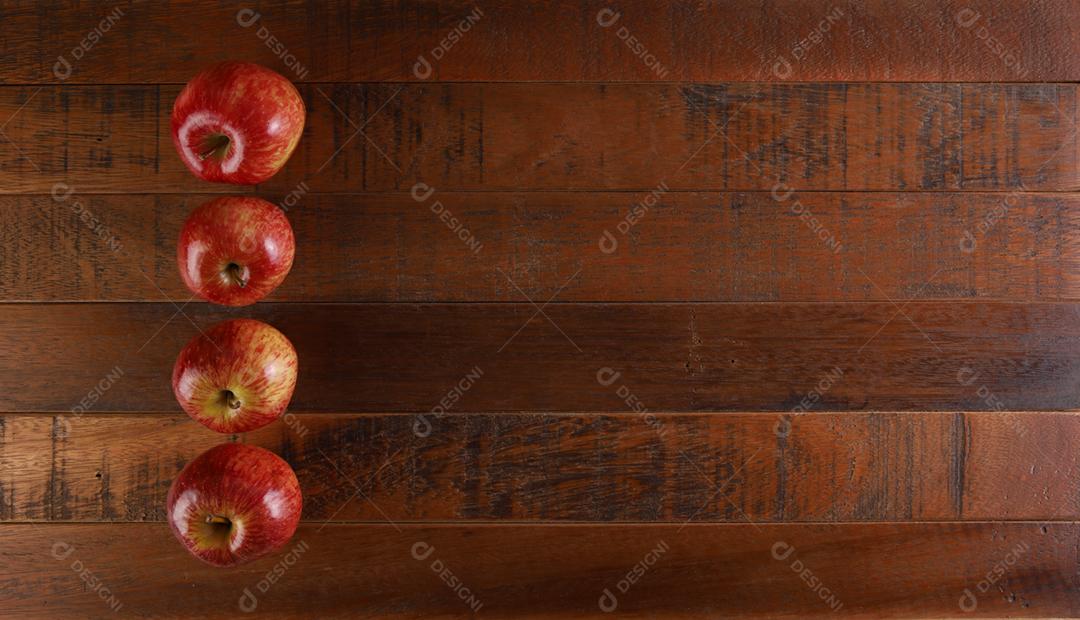 Várias maçãs vermelhas com fundo de madeira rústica