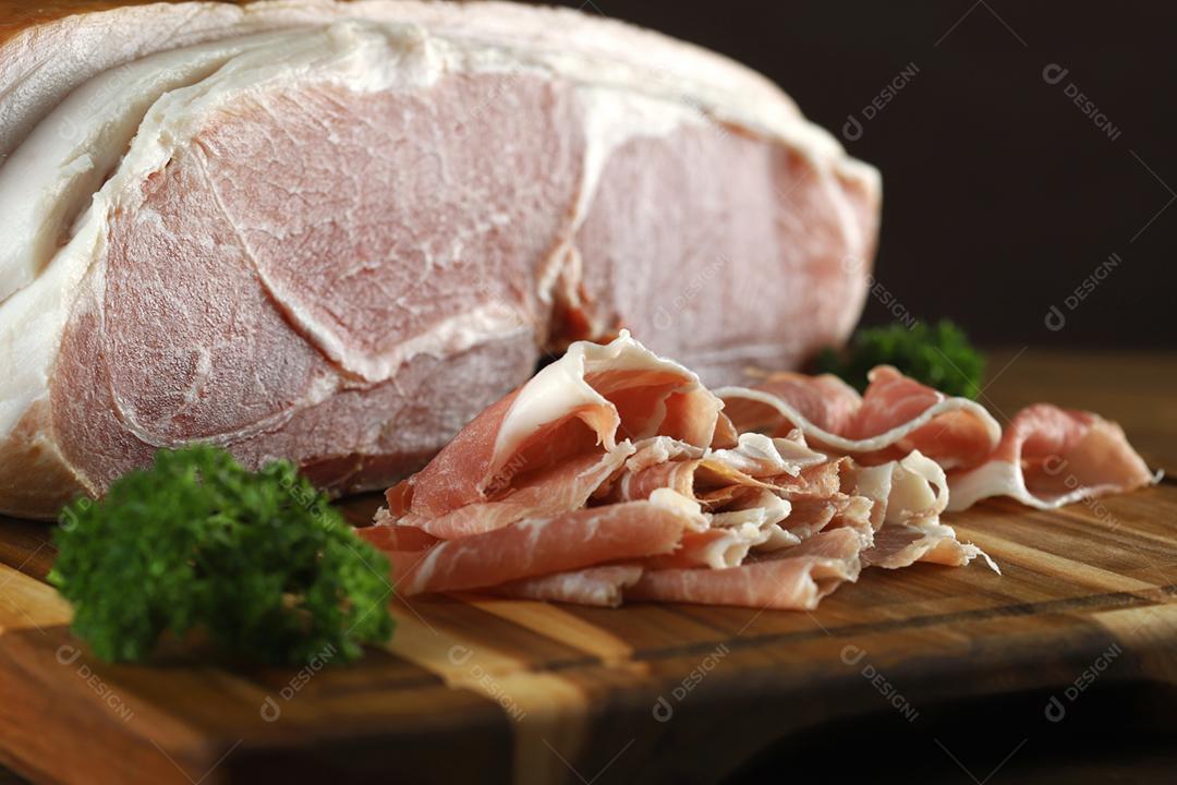 Presunto de Parma em close-up fatiado na placa de madeira