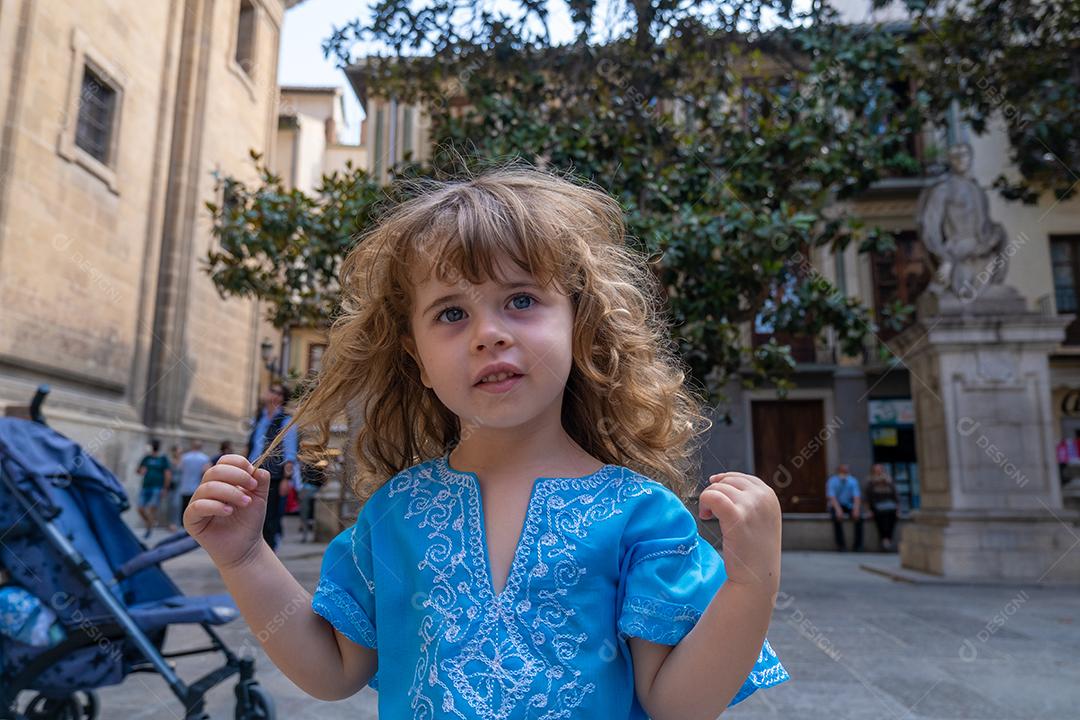 Linda loira em trajes árabes posando para a câmera nas ruas de Granada, Espanha