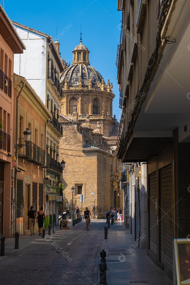 Vista de turistas nas ruas de Granada com uma igreja no fundo.