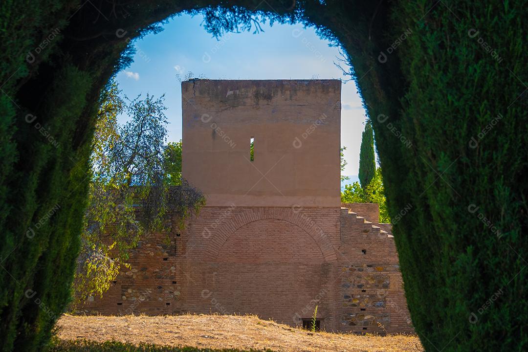 Vista do edifício entre o arco verde das plantas em Alhambra.
