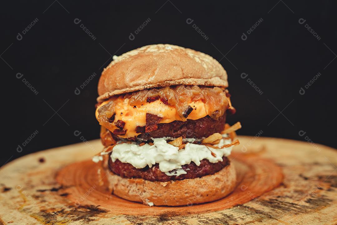 Comida sanduiche hamburguer sobre uma mesa de madeira