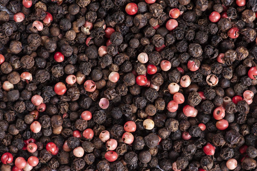 Fundo com pimenta preta e rosa. Copie o espaço.