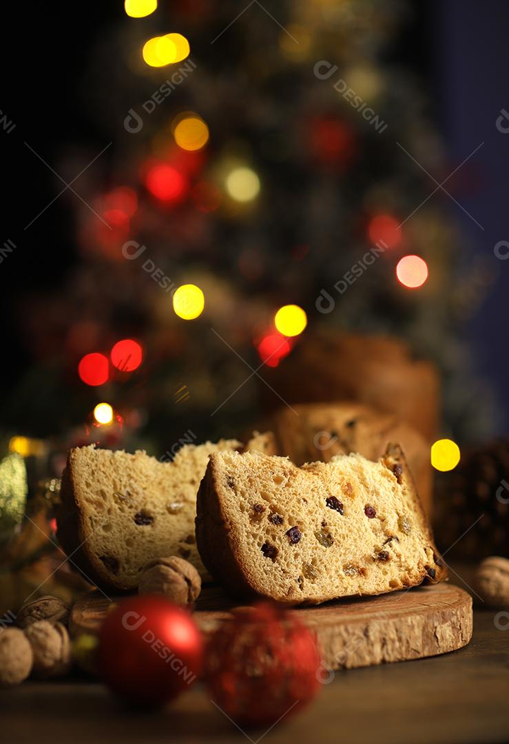 Deliciosa fatia de panetone com frutas cristalizadas em cima da mesa em um fundo desfocado.