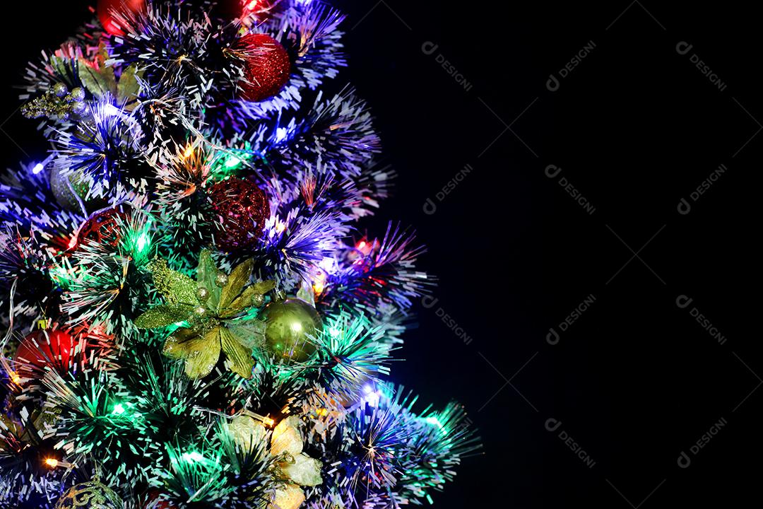 Árvore de Natal decorada em fundo preto.
