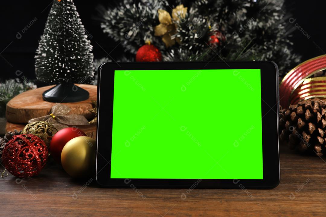 Tablet em fundo preto com decoração de Natal e madeira