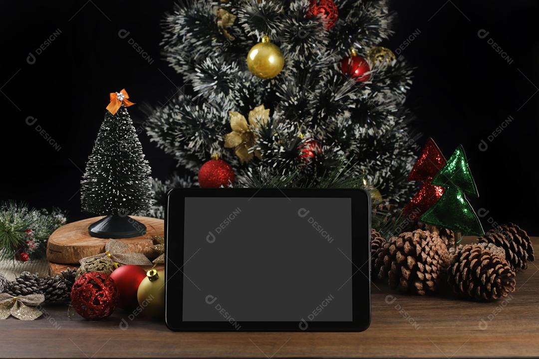 Tablet em fundo preto com decoração de Natal e madeira