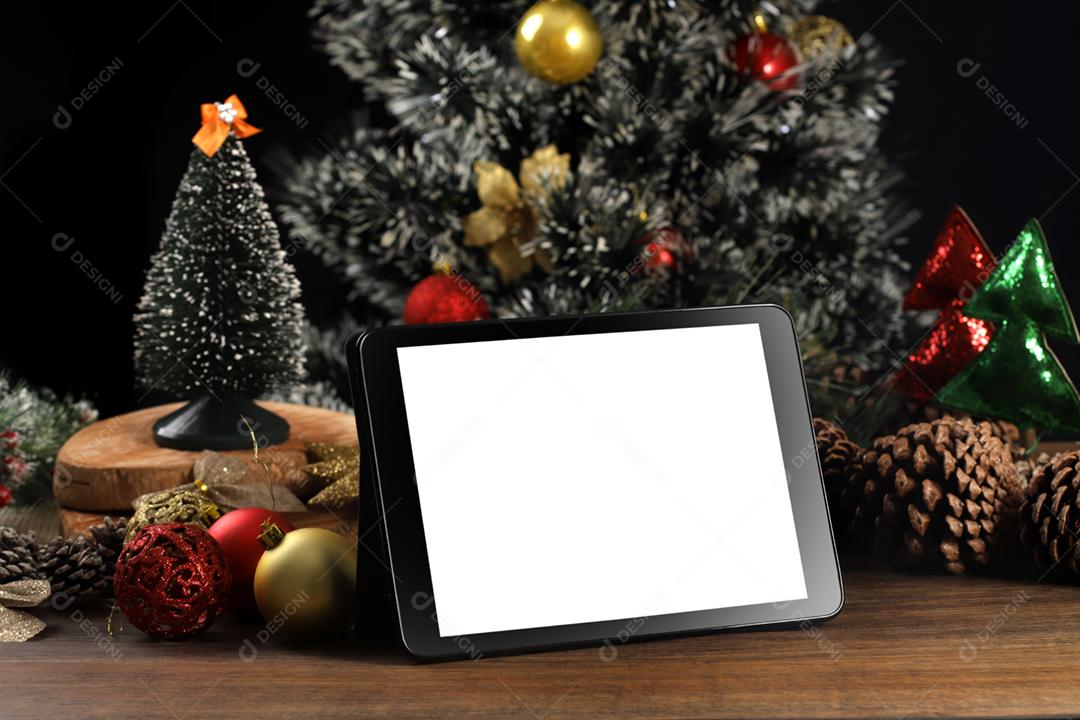 Tablet em fundo preto com decoração de Natal e madeira