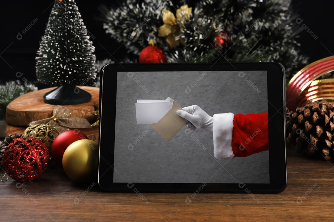 Tablet em fundo preto com decoração de Natal e madeira