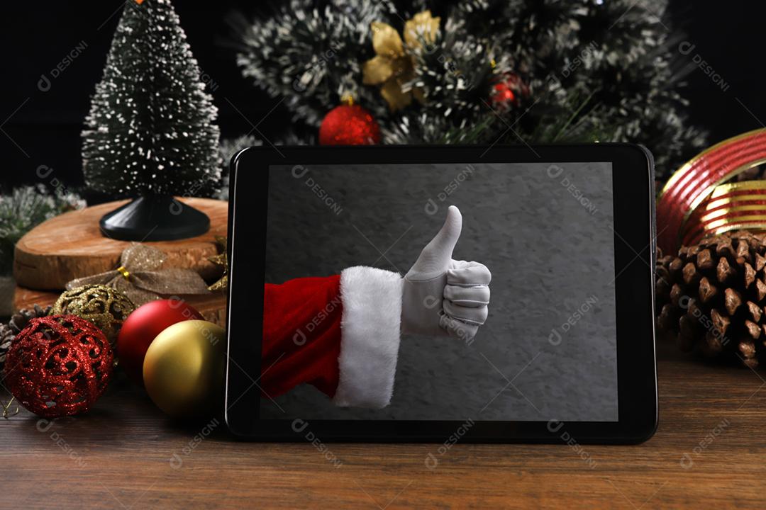 Tablet em fundo preto com decoração de Natal e madeira