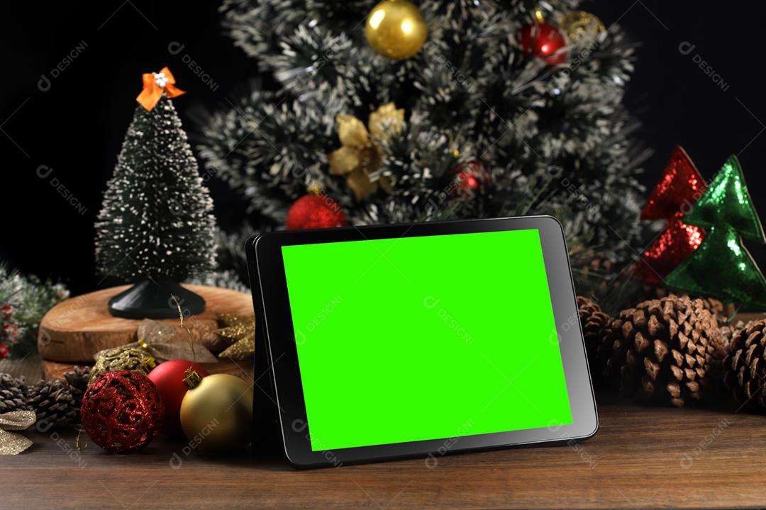 Tablet em fundo preto com decoração de Natal e madeira