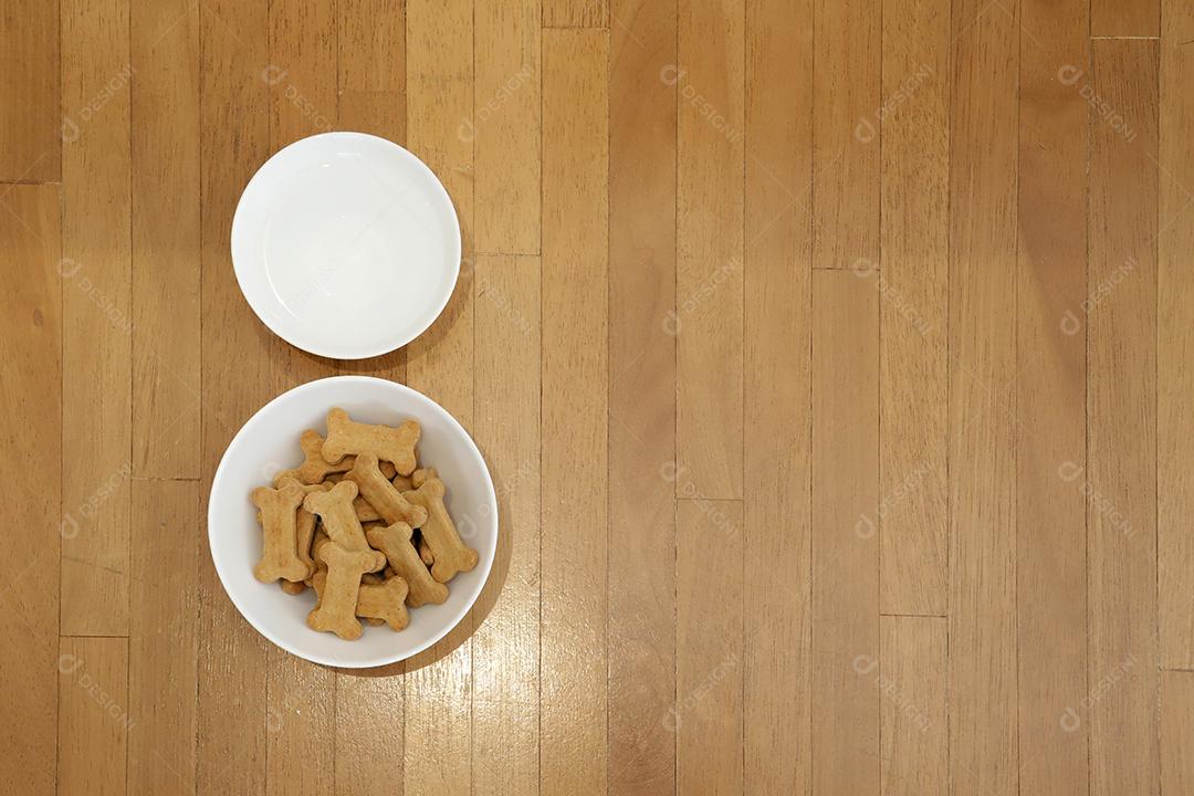 comida de cachorro seca e água na tigela na vista superior de fundo de madeira.