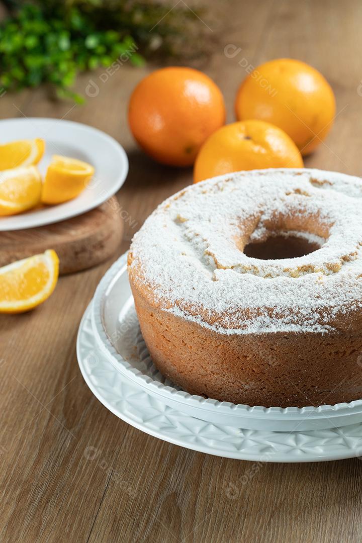 Bolo úmido de frutas laranja no prato com fatias de laranja na mesa de madeira. Delicioso café da manhã, hora do chá tradicional inglês. Receita de bolo de laranja.