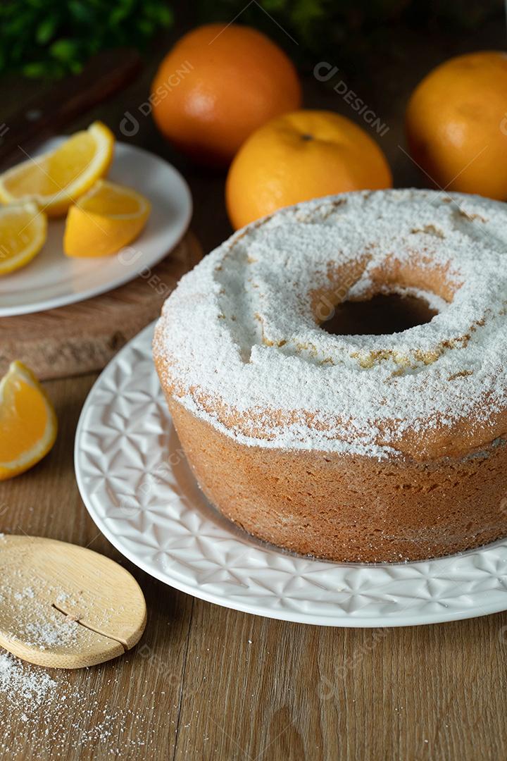 Bolo úmido de frutas laranja no prato com fatias de laranja na mesa de madeira. Delicioso café da manhã, hora do chá tradicional inglês. Receita de bolo de laranja.