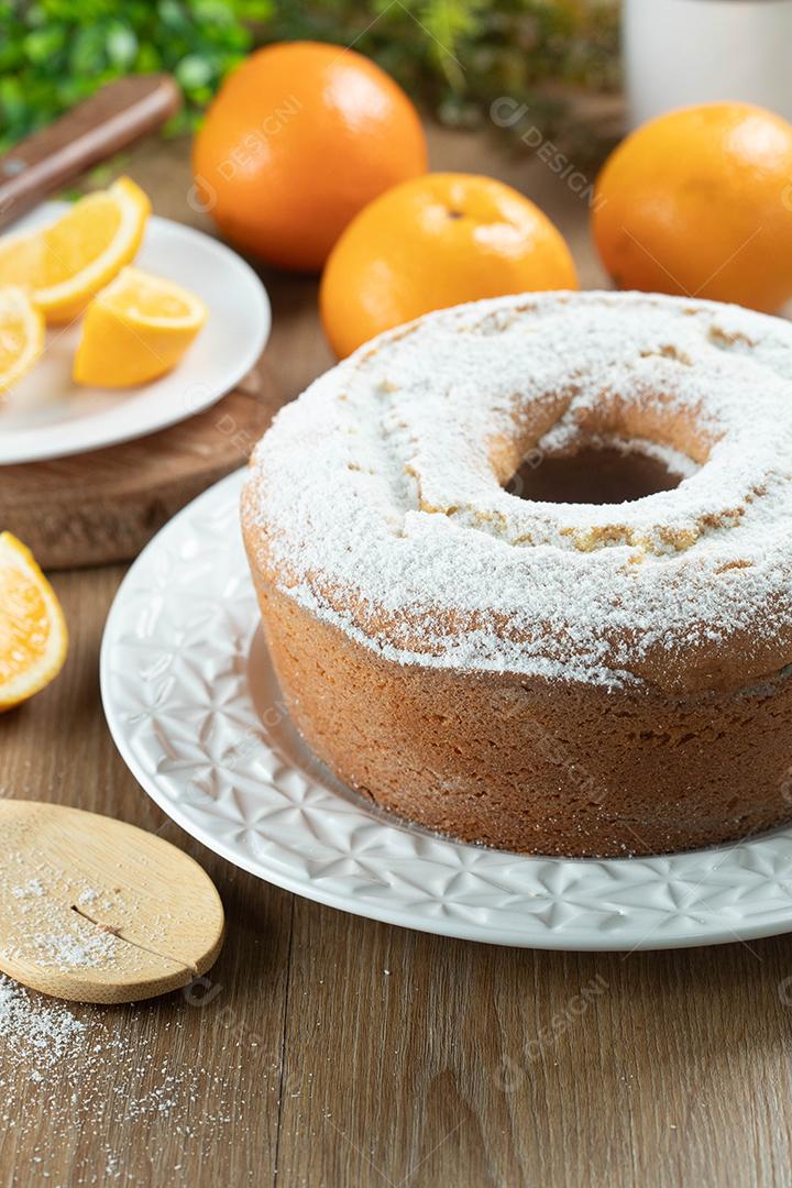 Bolo úmido de frutas laranja no prato com fatias de laranja na mesa de madeira. Delicioso café da manhã, hora do chá tradicional inglês. Receita de bolo de laranja.