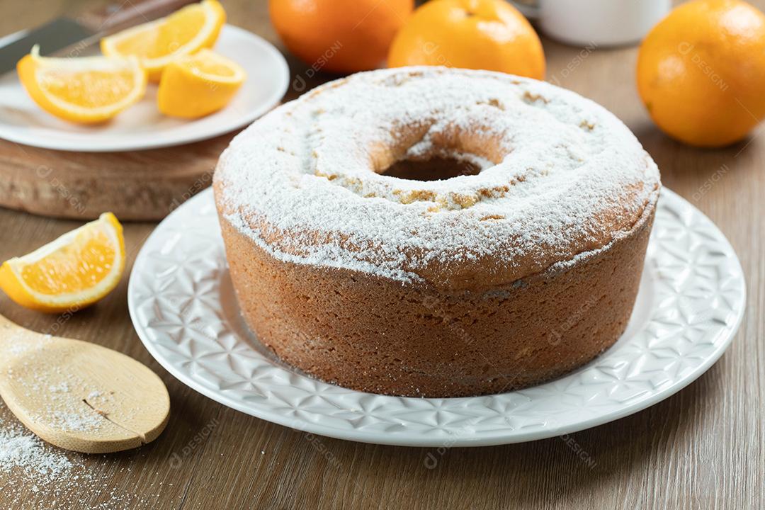 Bolo úmido de frutas laranja no prato com fatias de laranja na mesa de madeira. Delicioso café da manhã, hora do chá tradicional inglês. Receita de bolo de laranja.