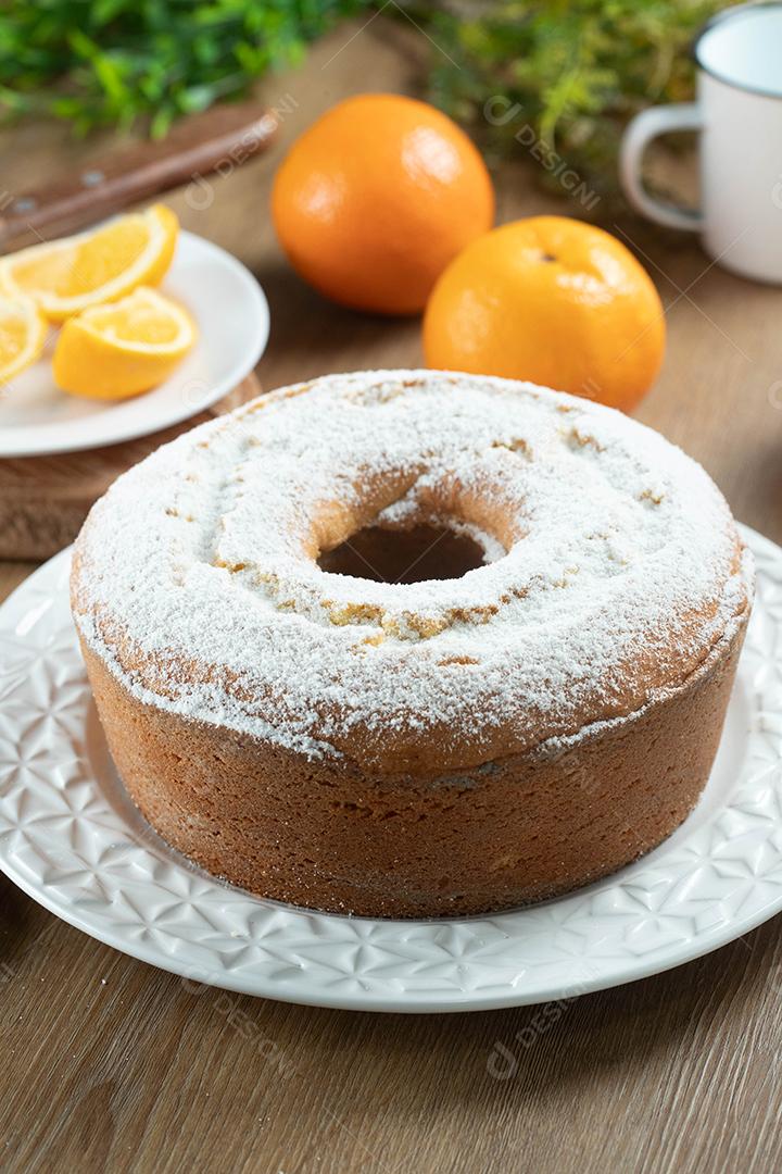 Bolo úmido de frutas laranja no prato com fatias de laranja na mesa de madeira. Delicioso café da manhã, hora do chá tradicional inglês. Receita de bolo de laranja.