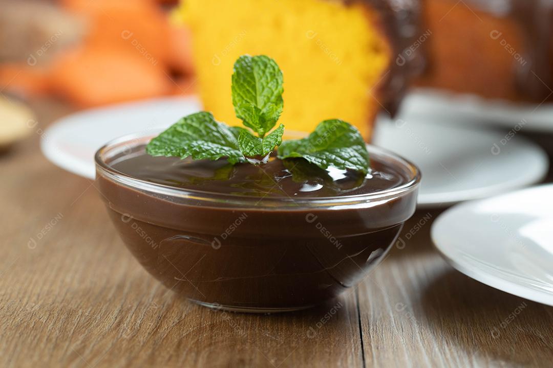 mousse de molho de chocolate com hortelã em frasco de vidro na mesa de madeira