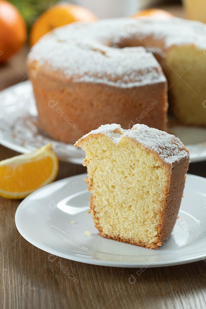 Feche o pedaço de bolo de frutas laranja úmida no prato com fatias de laranja na mesa de madeira. Delicioso café da manhã, hora do chá tradicional inglês. Receita de bolo de laranja.