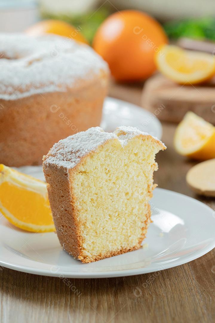 Pedaço de bolo de frutas laranja úmida no prato com fatias de laranja na mesa de madeira. Delicioso café da manhã, hora do chá tradicional inglês. Receita de bolo de laranja.