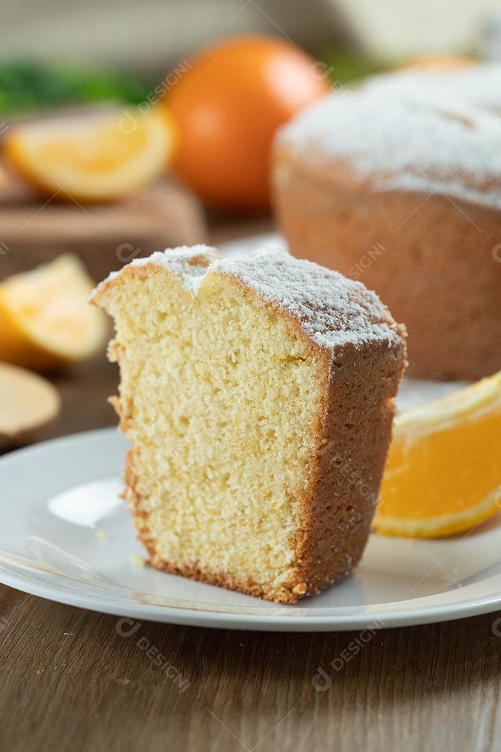 Feche o pedaço de bolo de frutas laranja úmida no prato com fatias de laranja na mesa de madeira. Delicioso café da manhã, hora do chá tradicional inglês. Receita de bolo de laranja.
