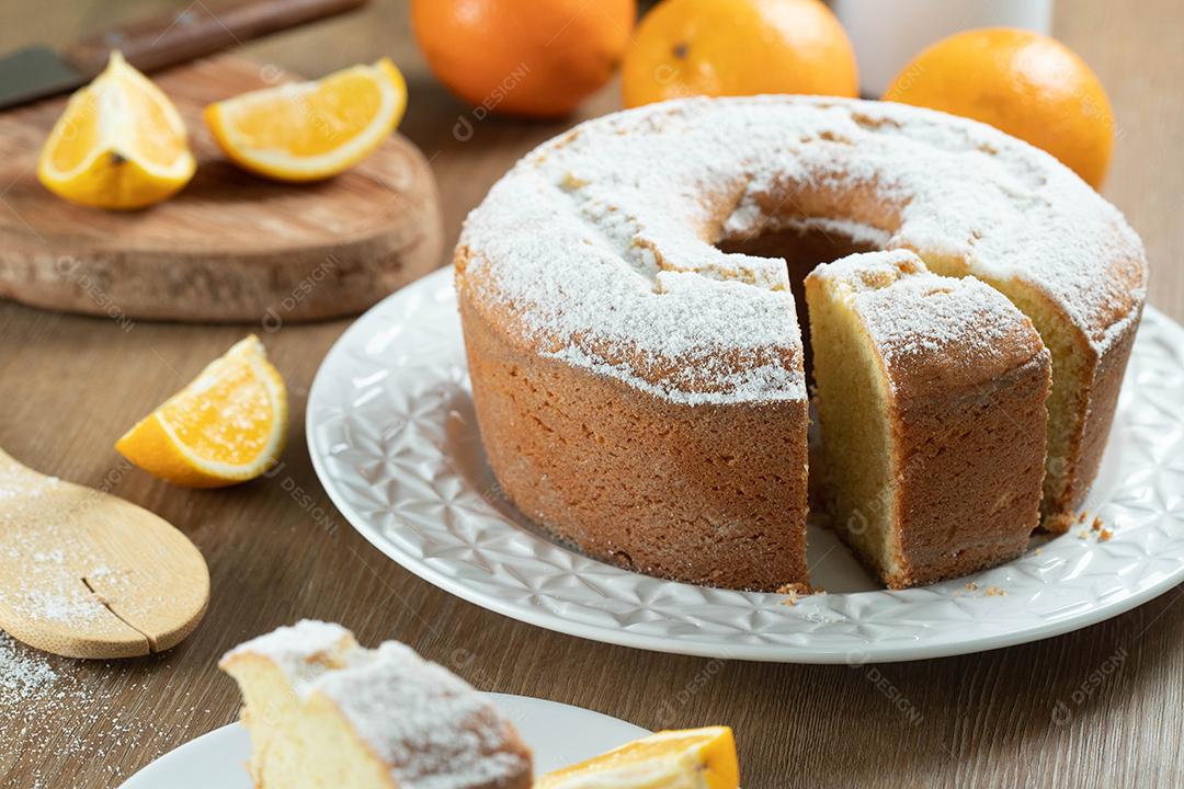 Pedaço de bolo de frutas laranja úmida no prato com fatias de laranja na mesa de madeira. Delicioso café da manhã, hora do chá tradicional inglês. Receita de bolo de laranja.