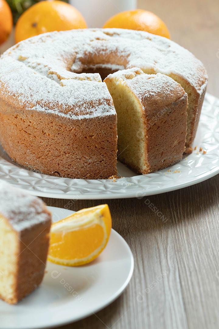 Feche o pedaço de bolo de frutas laranja úmida no prato com fatias de laranja na mesa de madeira. Delicioso café da manhã, hora do chá tradicional inglês. Receita de bolo de laranja.