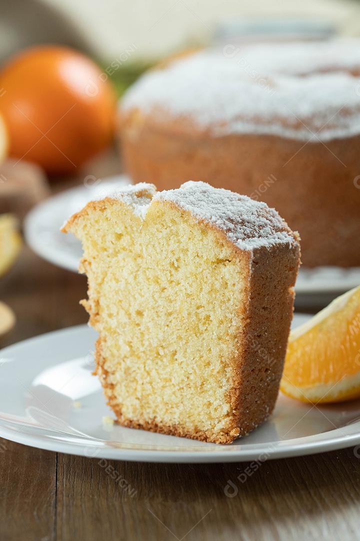Feche o pedaço de bolo de frutas laranja úmida no prato com fatias de laranja na mesa de madeira. Delicioso café da manhã, hora do chá tradicional inglês. Receita de bolo de laranja.