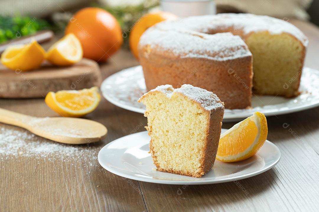 Feche o pedaço de bolo de frutas laranja úmida no prato com fatias de laranja na mesa de madeira. Delicioso café da manhã, hora do chá tradicional inglês. Receita de bolo de laranja.