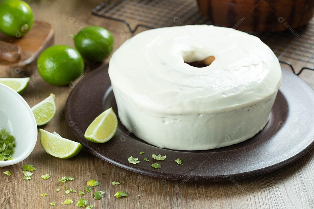 Bolo de frutas de limão úmido no prato com rodelas de limão na mesa de madeira. Delicioso café da manhã, hora do chá tradicional. Receita de bolo de limão